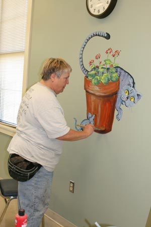 image of a senior painting a wall mural